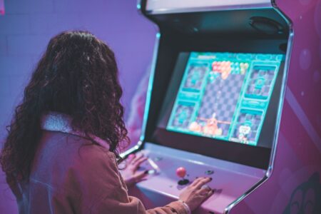 A classic upright arcade cabinet glowing in a dark room, representing the original Donkey Kong era