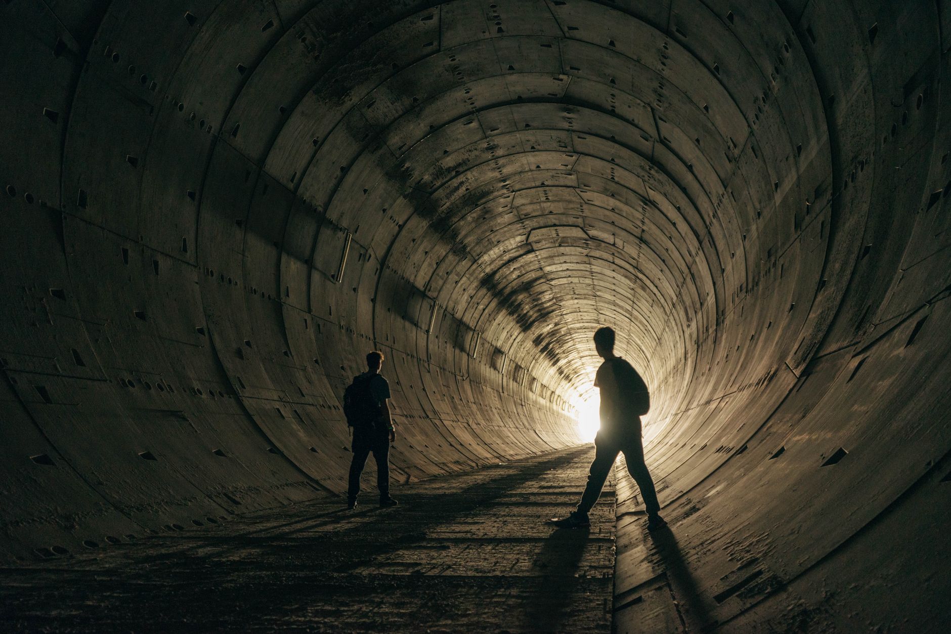 A dimly lit underground tunnel with rocky walls, representing hidden exploration routes