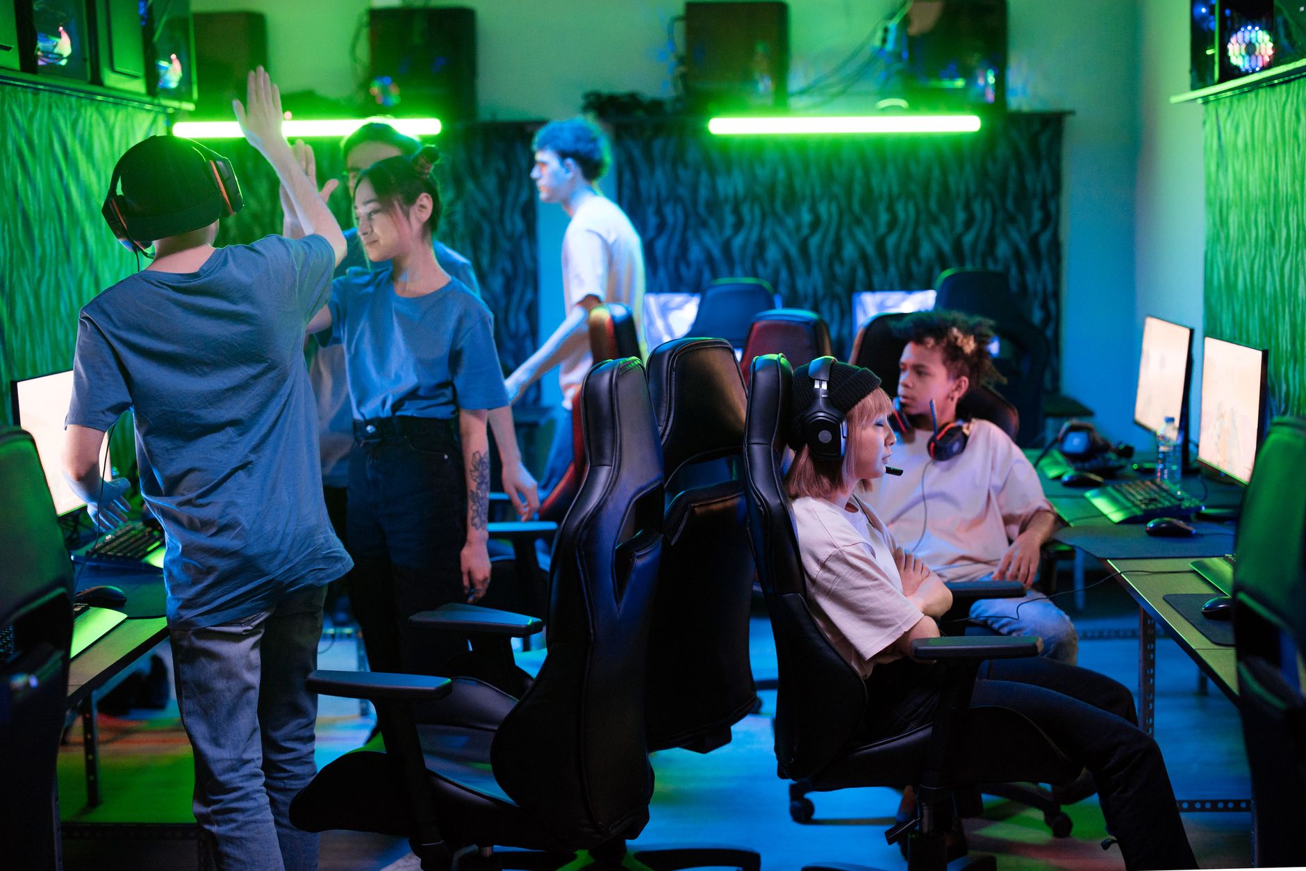 A group of people gathered around a screen discussing a video game, representing divided fan opinions online