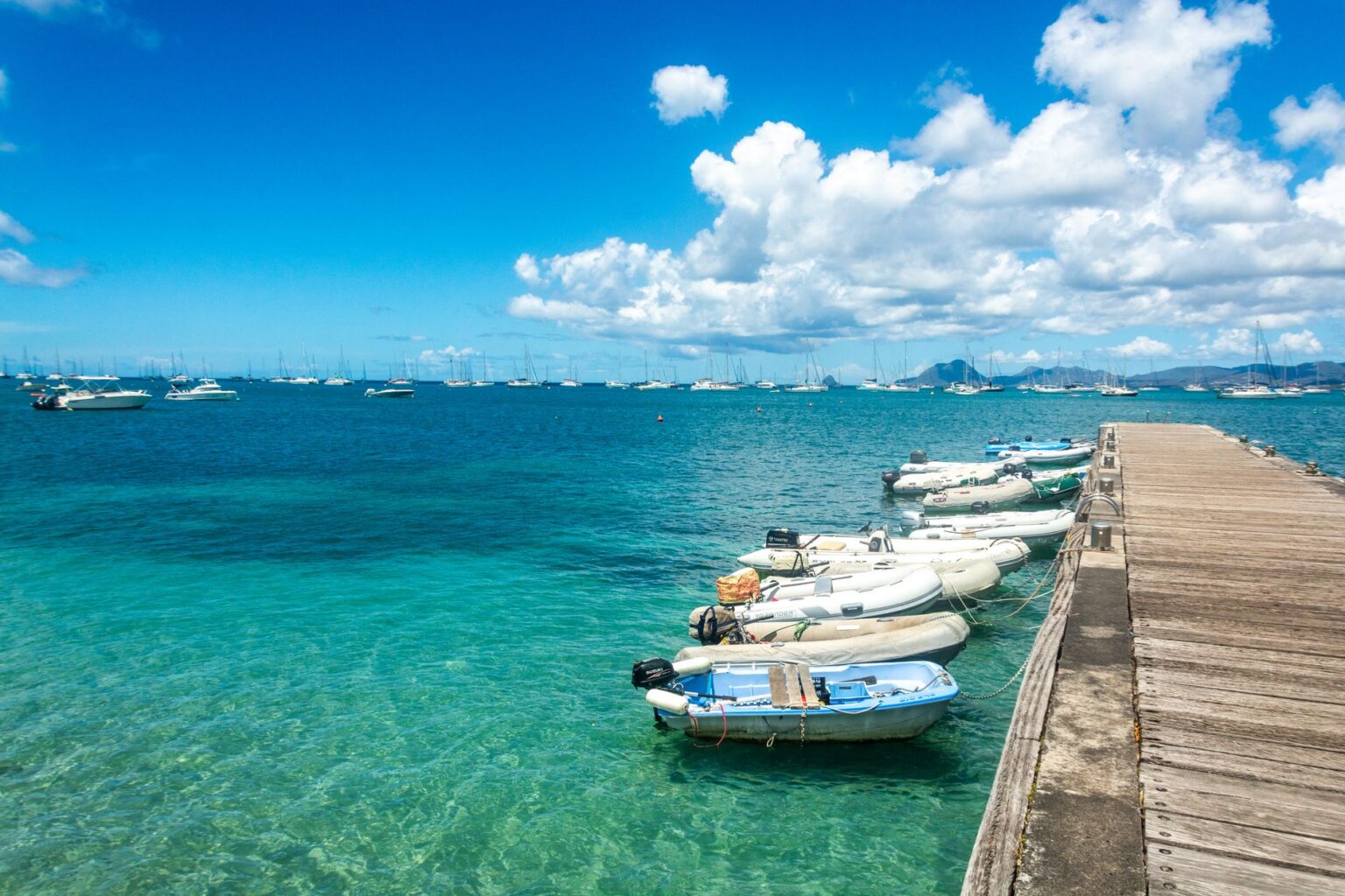 A wooden dock extending into tropical blue water, representing the beach setting associated with DKCR's jetski stages